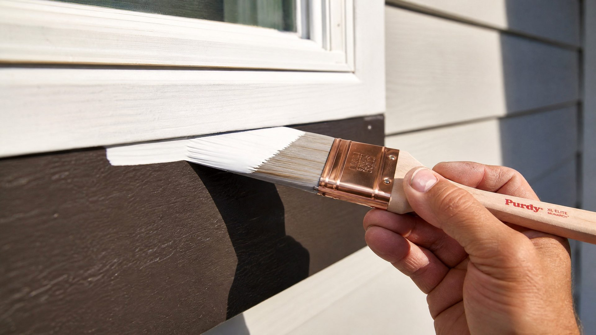 Careful brushwork cutting in crisp white trim on an exterior window